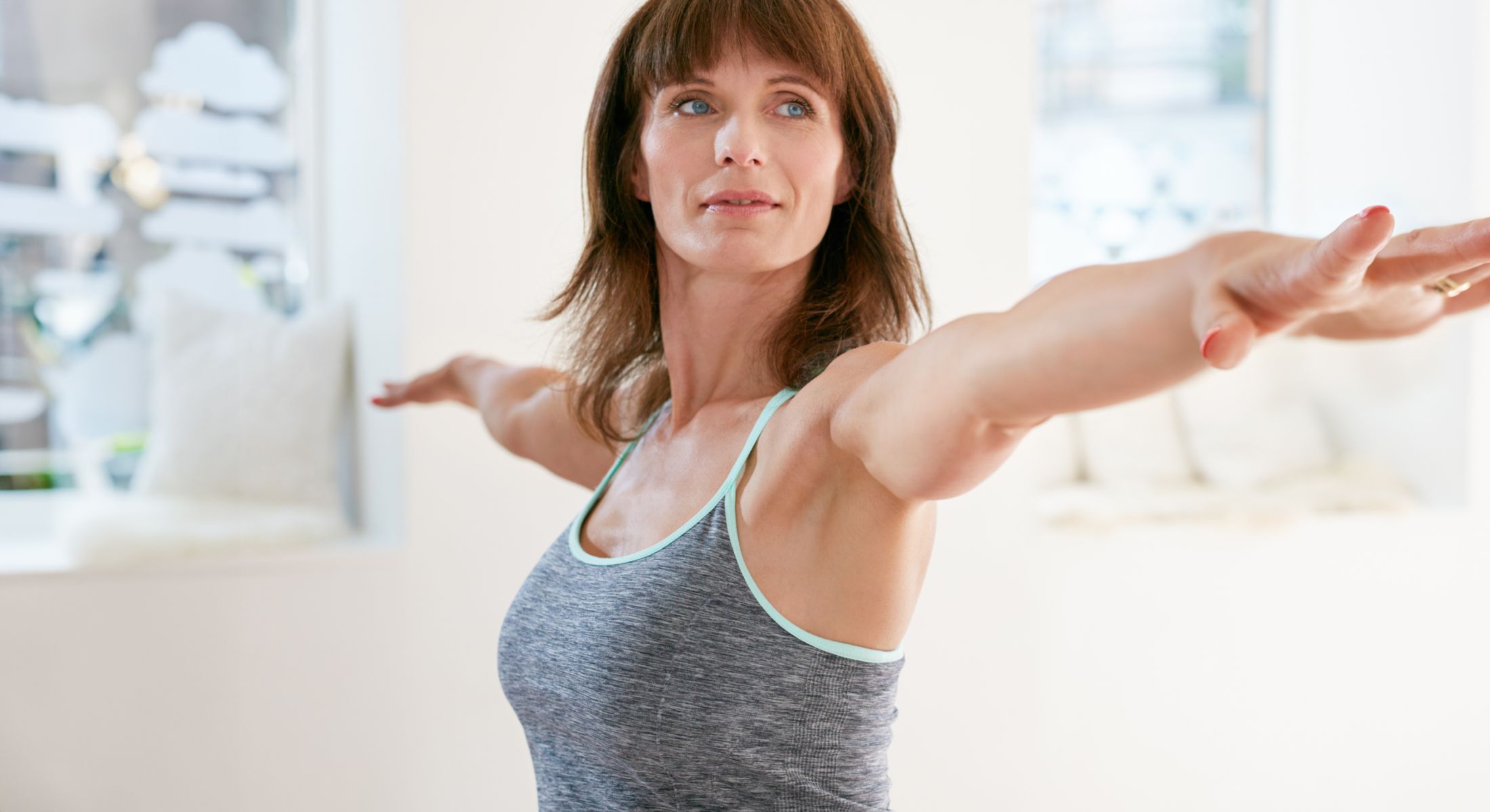Woman practicing yoga with arms extended.