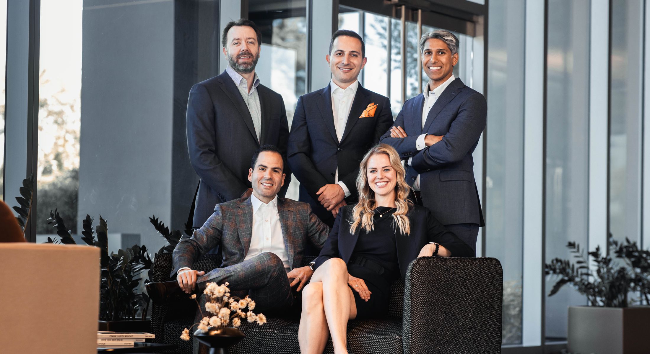 Group portrait of five professionals in business attire.
